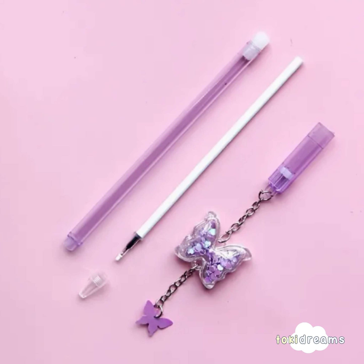gel pen with glitter-filled butterfly-shaped dome and metal charm in purple color on matching background
