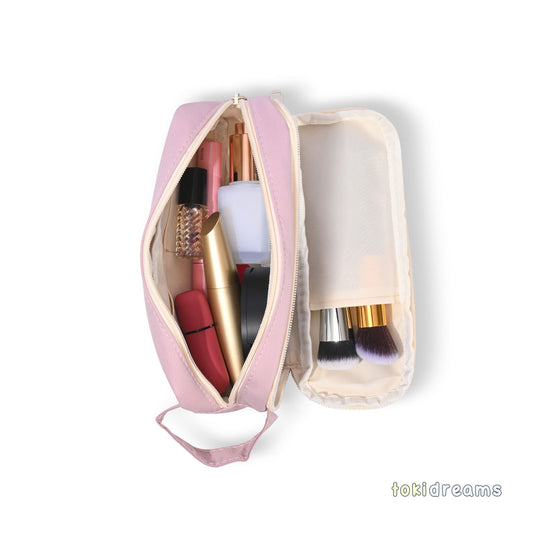 Pink cosmetic bag with makeup items on a white background