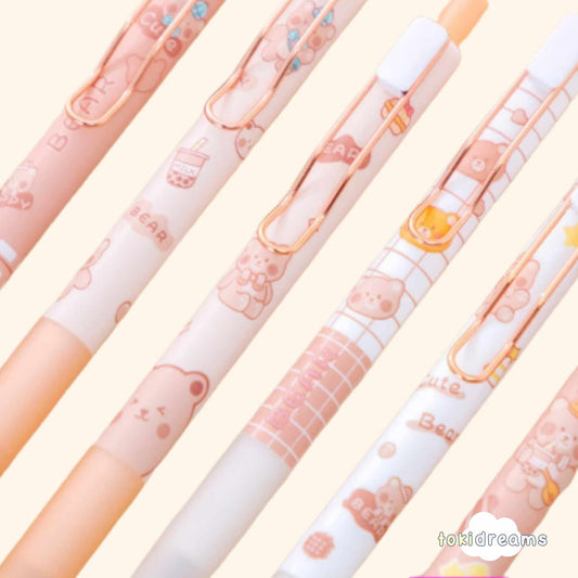 Close-up of 6 tan ballpoint pens with bear designs, checkered grip pattern for office use