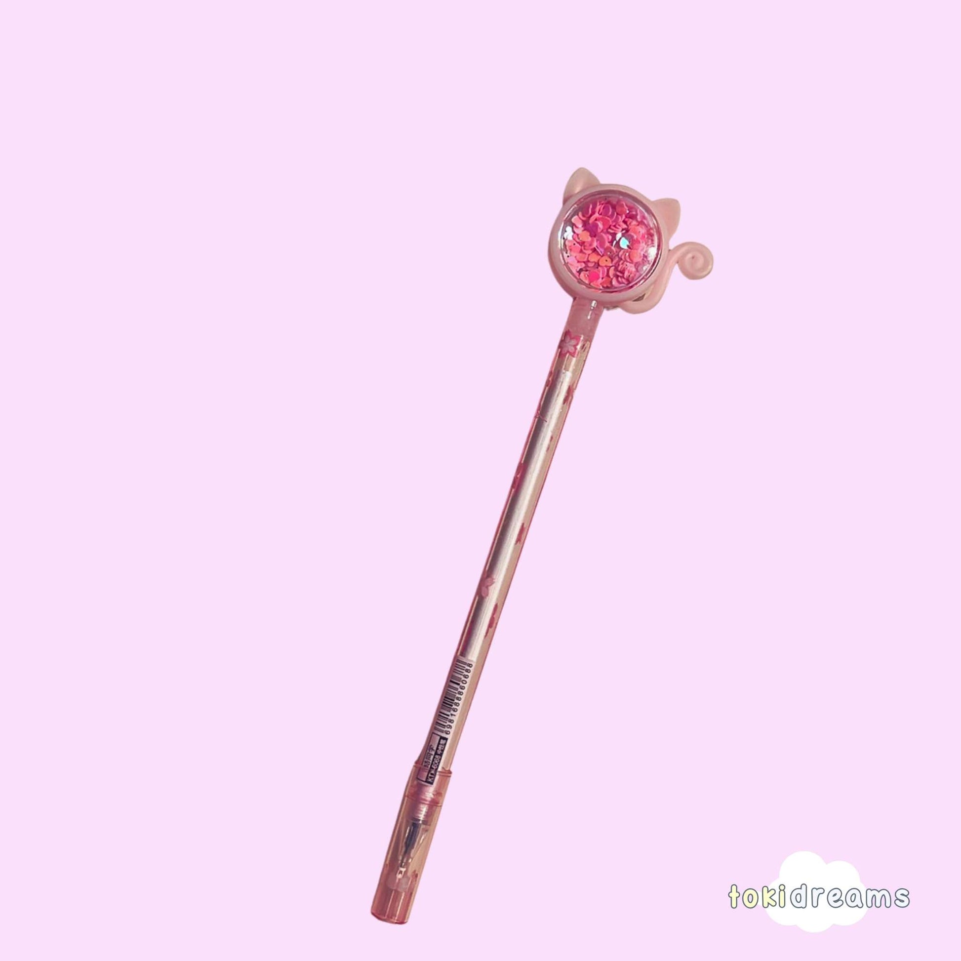 A pink and clear sparkle pen with a cat-themed design
