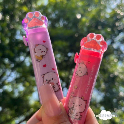 A hand holding a retractable handheld eraser with a cat-themed design, featuring a cute cartoon kitty face and paw print accents.